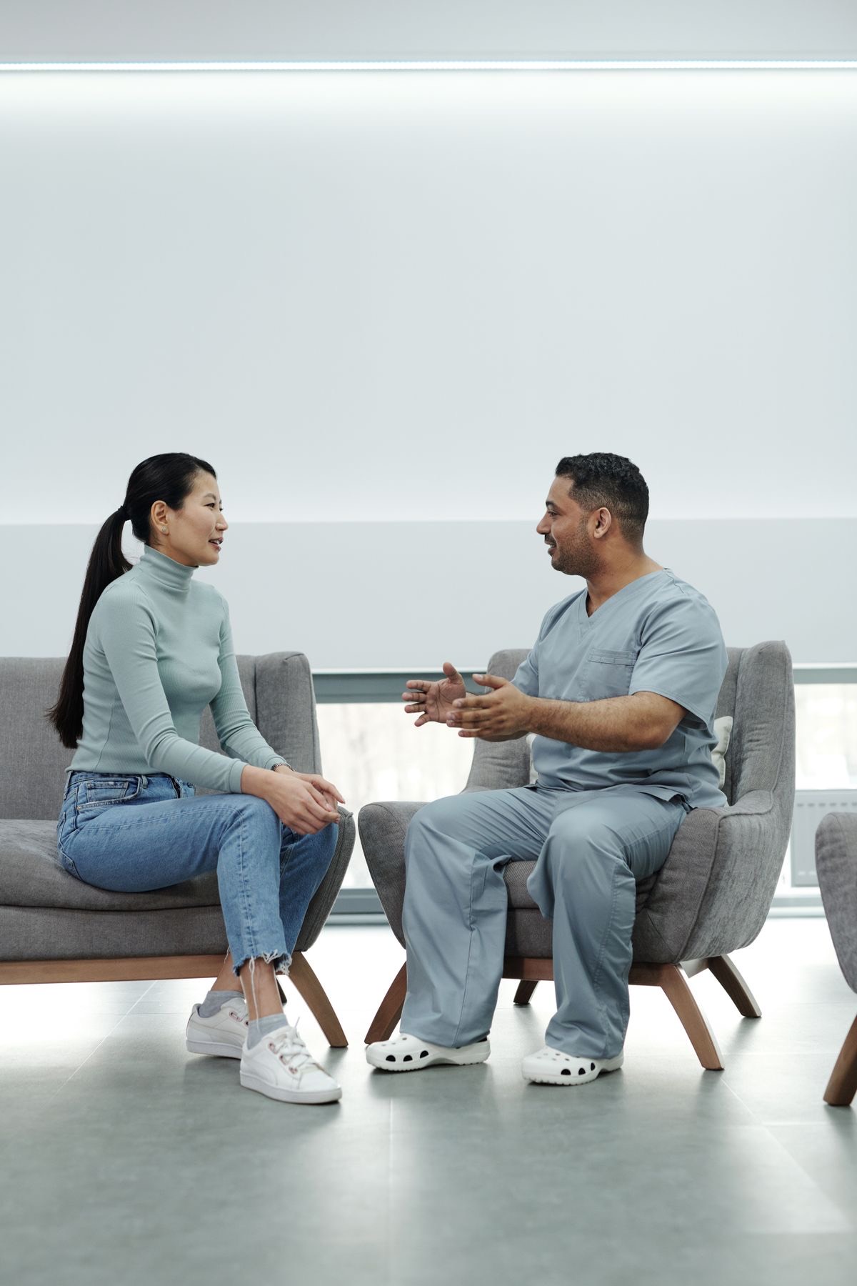 Profesional de la salud conversando con una paciente en un espacio de atención moderno y luminoso