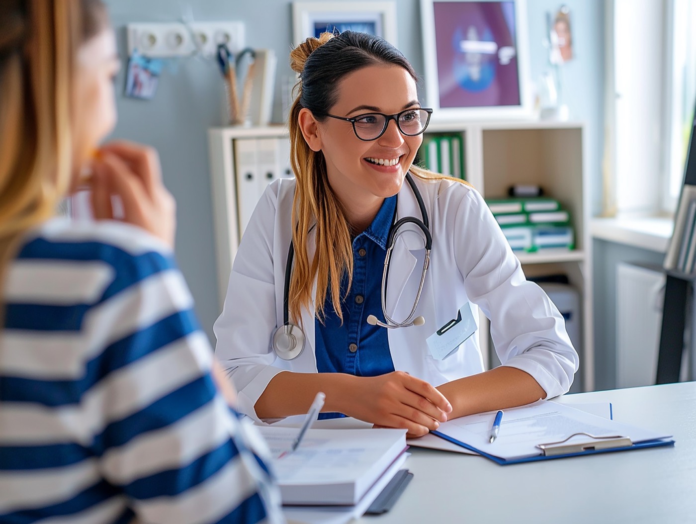 Doctora sonriendo mientras atiende a una paciente en su consulta
